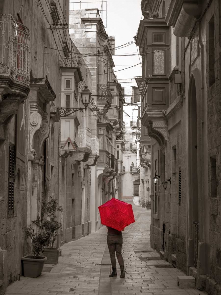 Tourist with umbrella at narrow street on Birgu, Malta
