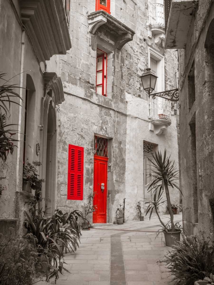 Narrow street through traditional maltese houses in Birgu, Malta