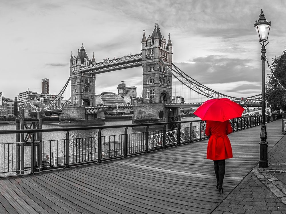 Tourist with red umbrella on promenade near Tower bridge, London, UK