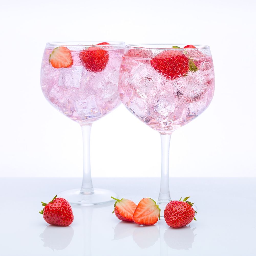 Gin with strawberries on white background