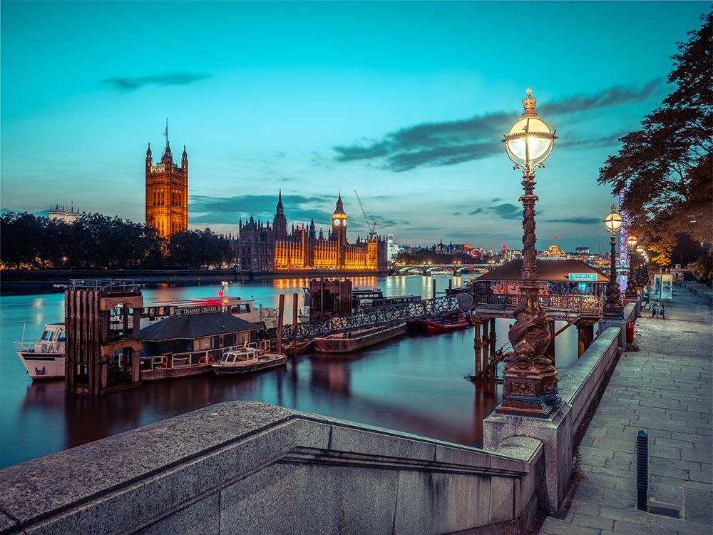 Evening view of the houses of parliament from across the river thames, with a leading steps