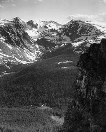 View of snow-capped mountain timbered area below, in Rocky Mountain National Park, Colorado, ca. 194