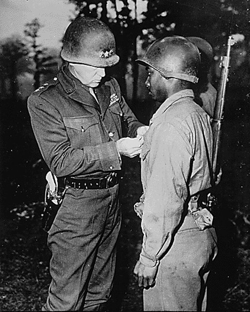 WWII Lt. Gen. George S. Patton-U.S. Third Army commander-pins the Silver Star on Private Ernest A. J