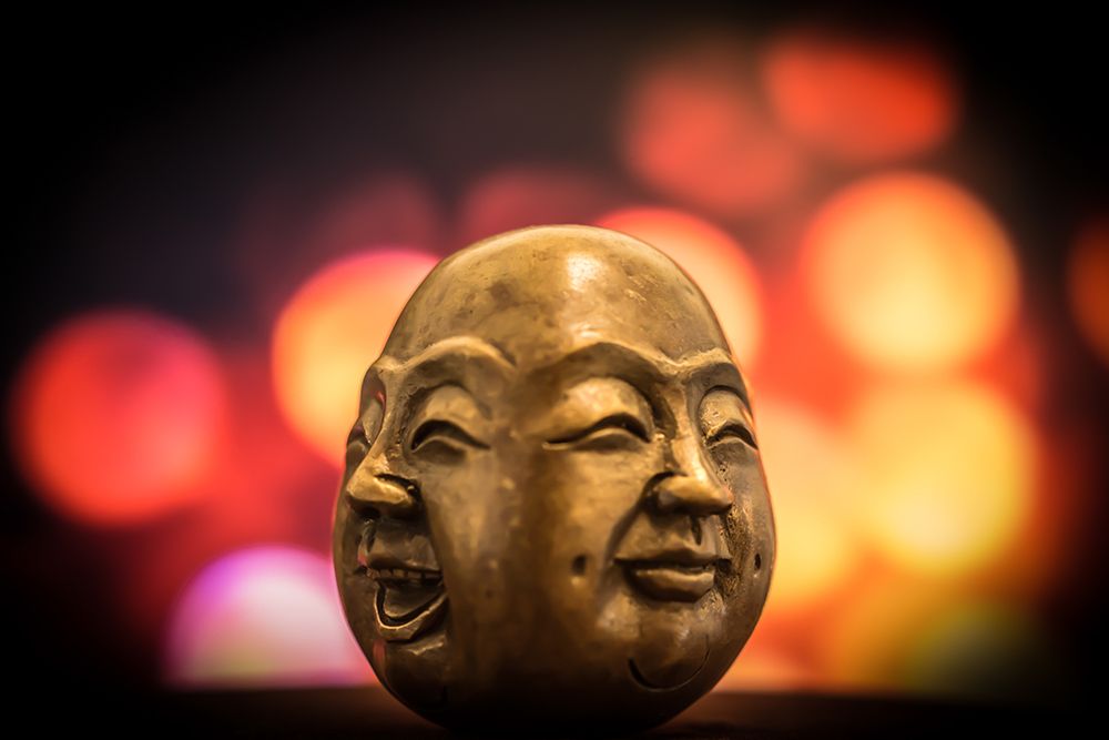 A Brass Figurine Depicting two Smiling Faces of Buddha